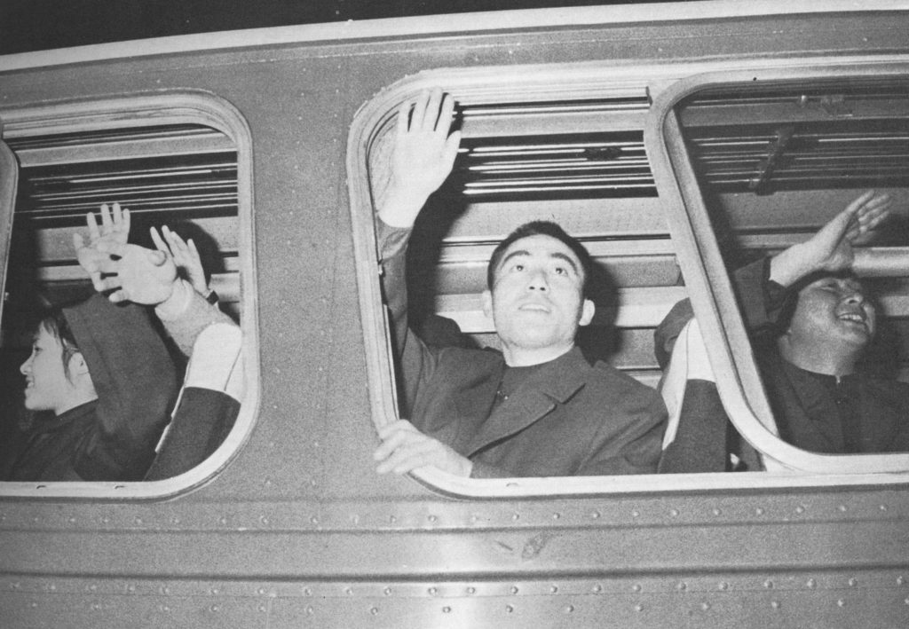 A member of the Chinese table tennis team waves out of a tour bus window