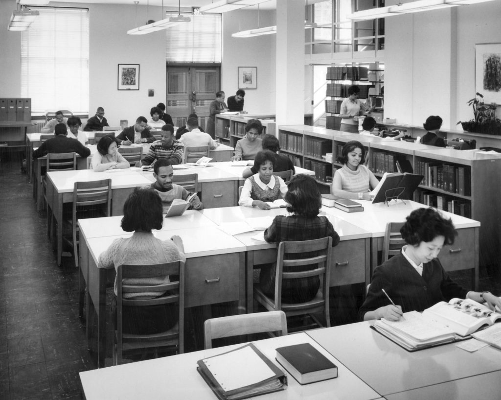 African American students sit at tables and study at the Atlanta University library around 1960. 