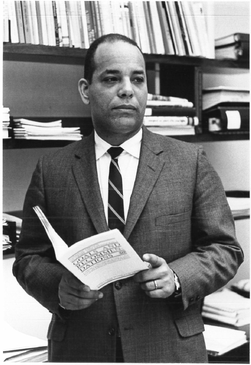 Portrait of Christopher Edley, a Black man in a suit with books behind him. He was the Ford Foundation's first Black program officer, and an early proponent of civil rights funding at the foundation.