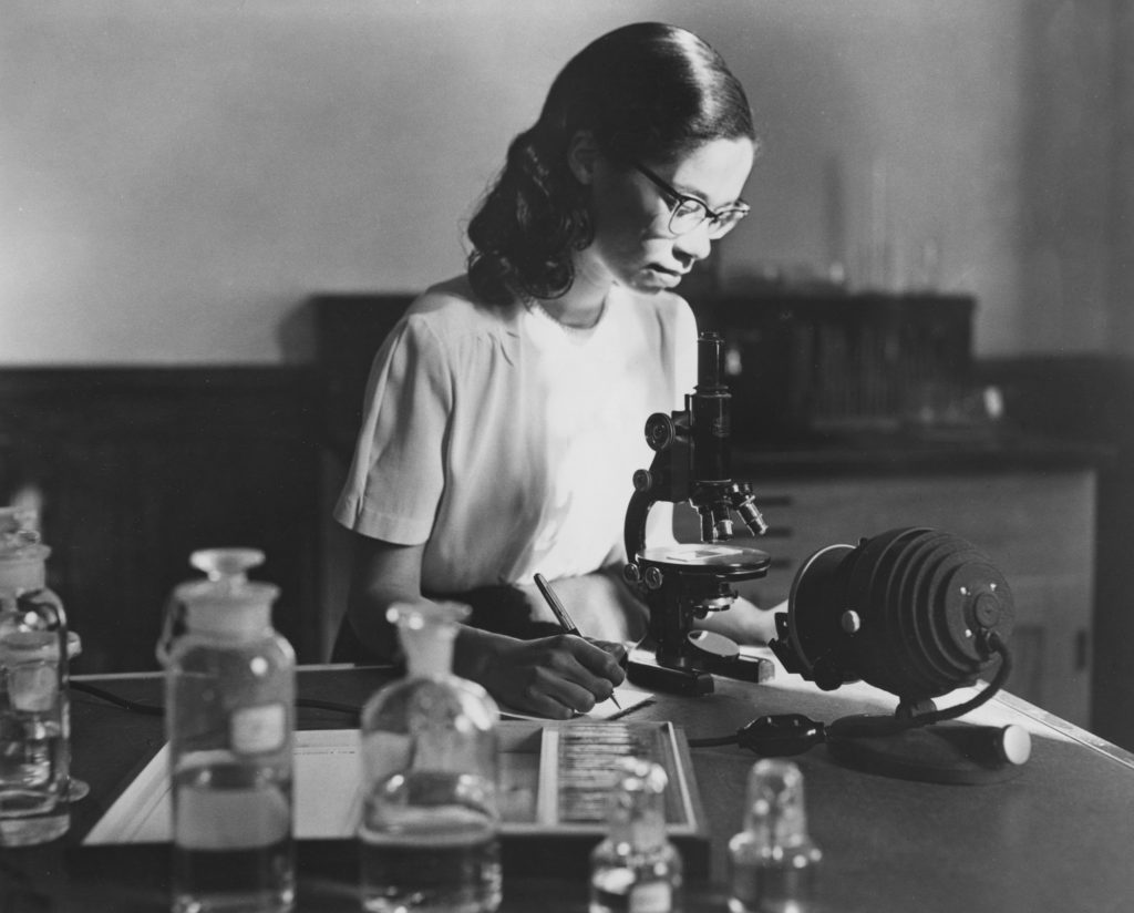 A Black student looks through a microscope. Early foundation grantmaking related to African-Americans was mostly in the field of education.