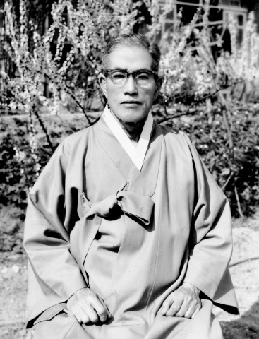 Black and white photograph of Choi Hyon Pai sitting, wearing glasses and traditional Korean robe.