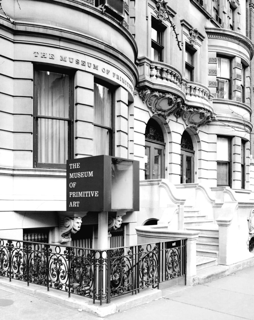 A grayscale photograph of the facade of the Museum of Primitive Art taken from the corner of the sidewalk.
