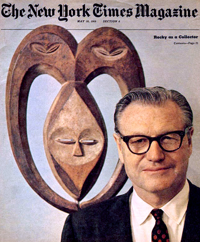 An image of Nelson Rockefeller shot from the shoulders-up in front of a carved wooden mask. This appeared on the cover of The New York Times Magazine with the headline "Rocky as a Collector."